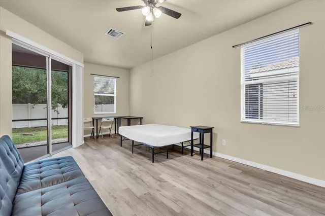a bedroom with a bed a chandelier and a dresser