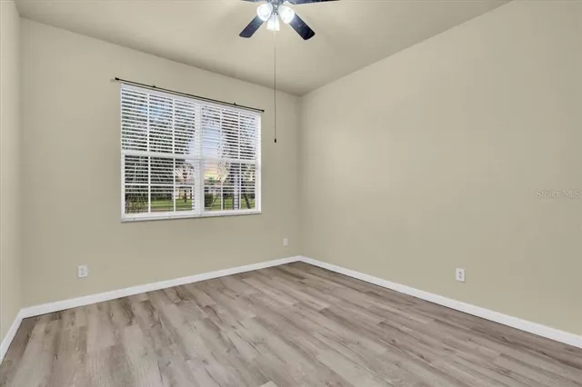 a view of an empty room with window chandelier fan