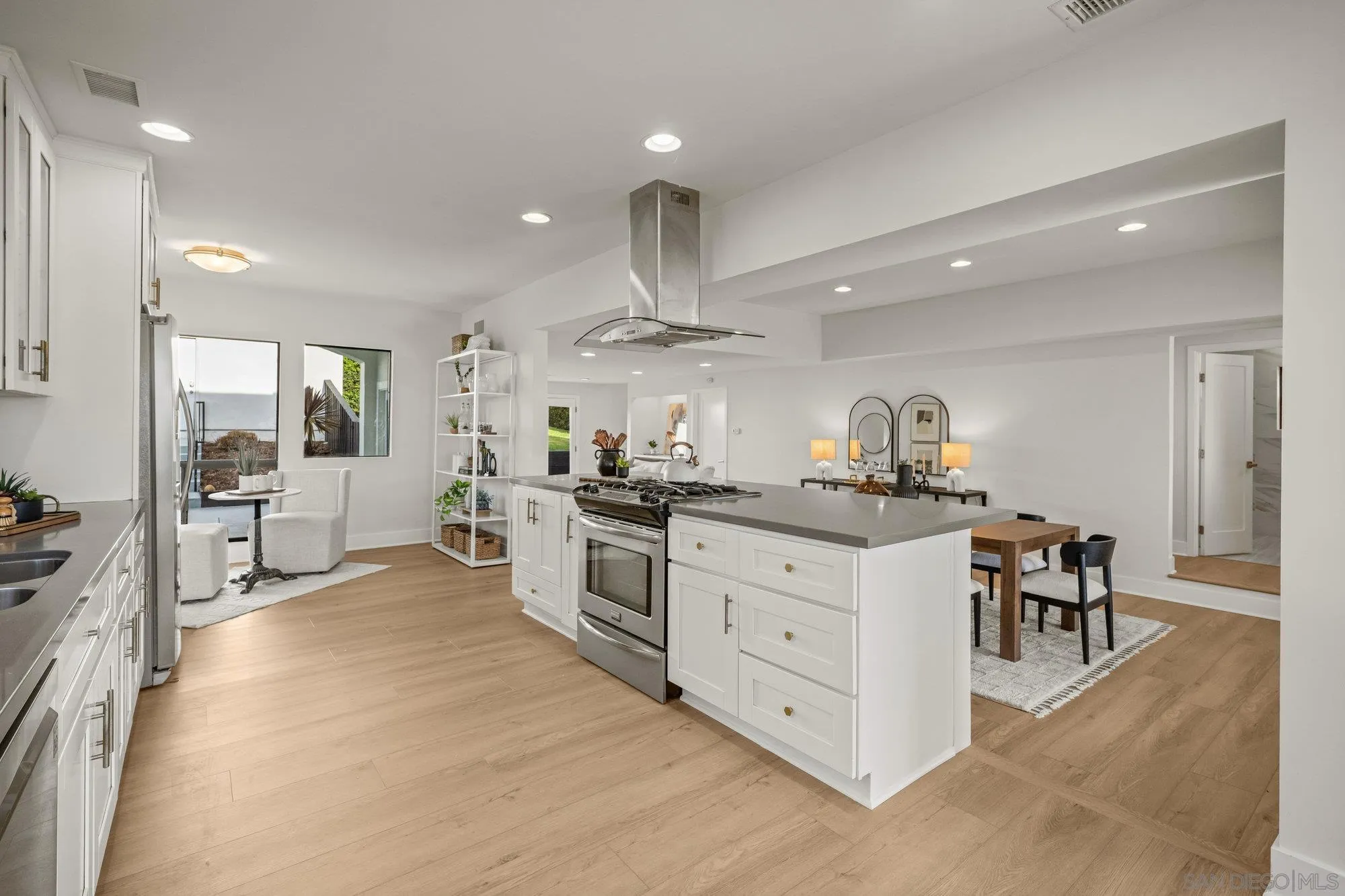 1712 Beryl Street San Diego, CA 92109 - Photo 10 of 37 a kitchen with stainless steel appliances kitchen island granite countertop a stove a sink a dining table and chairs
