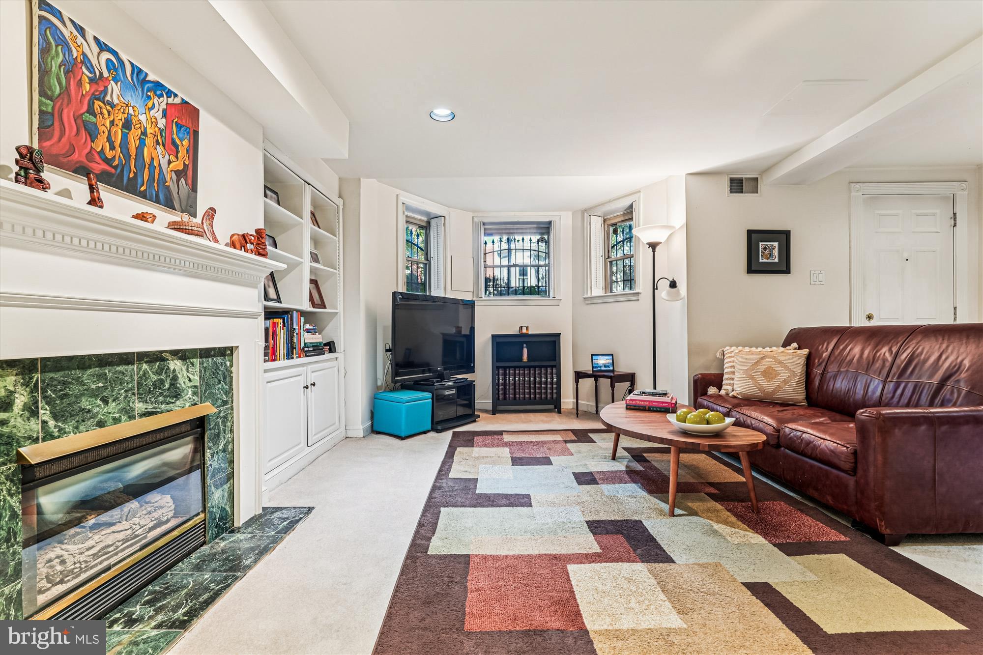 1420 Q Street Northwest Washington, DC 20009 - Photo 56 of 86 a living room with furniture a fireplace and a painting on the wall