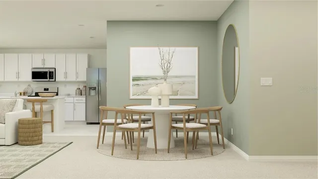 a kitchen with stainless steel appliances a table and chairs