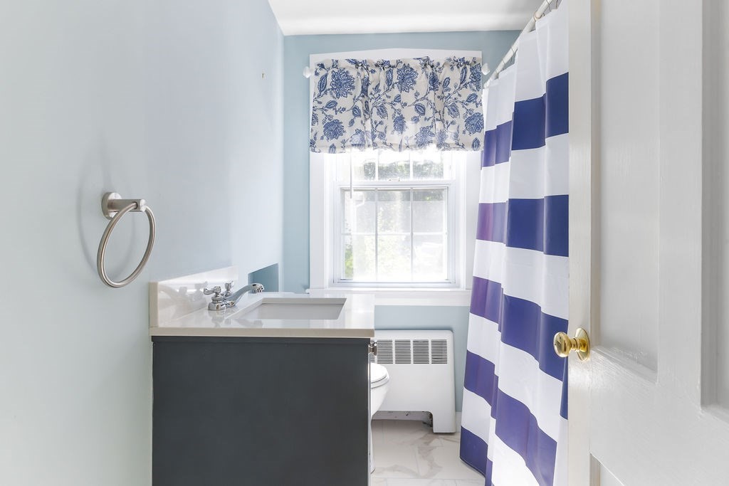 48 Taylor Street Needham, MA 02494 - Photo 18 of 25 a bathroom with a sink and a mirror