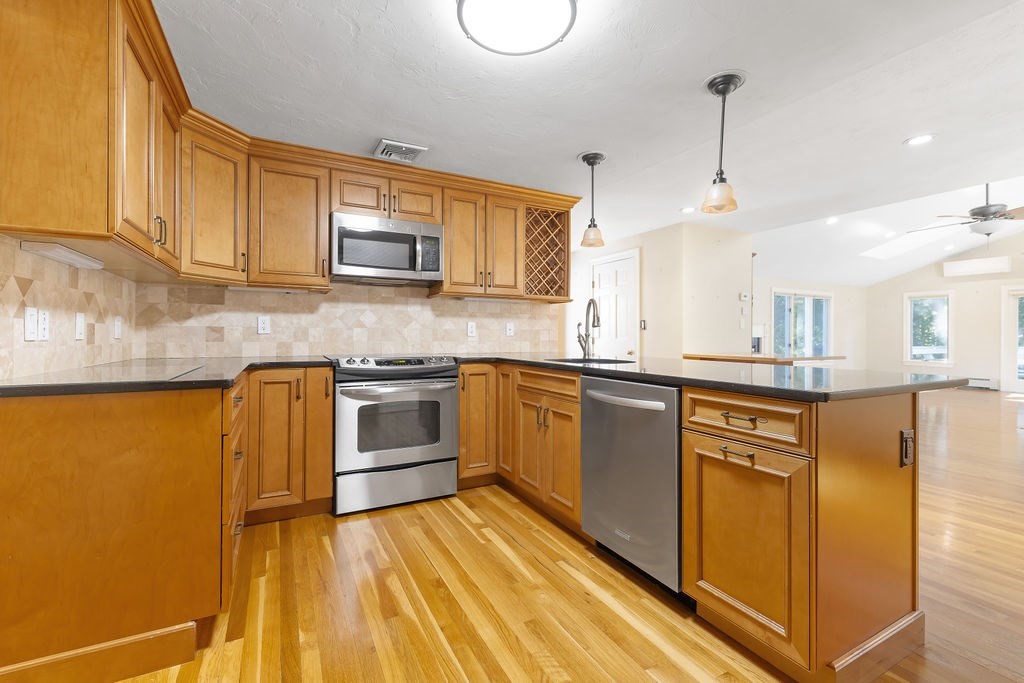 48 Taylor Street Needham, MA 02494 - Photo 8 of 25 a kitchen with stainless steel appliances granite countertop a sink a stove and a refrigerator
