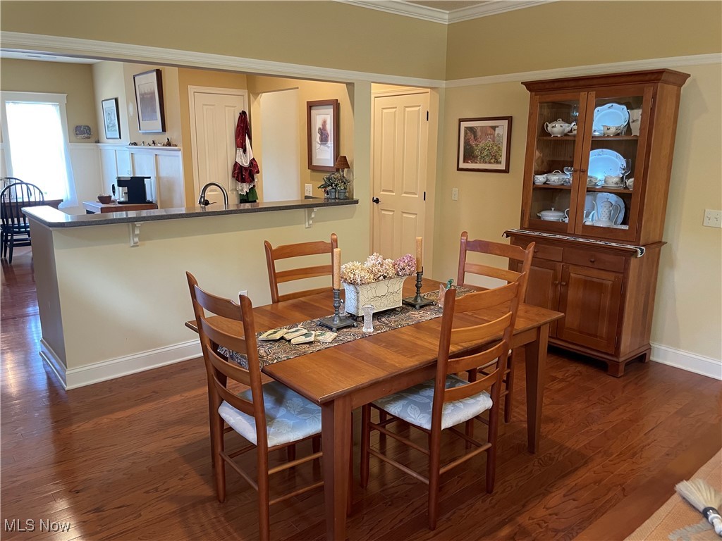 8322 Forest Ridge Street Northwest Massillon, OH 44646 - Photo 13 of 33 Dining room featuring dark wood finished floors and crown molding