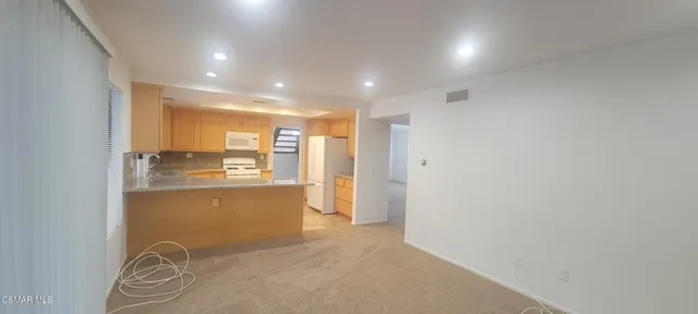a view of kitchen and empty room