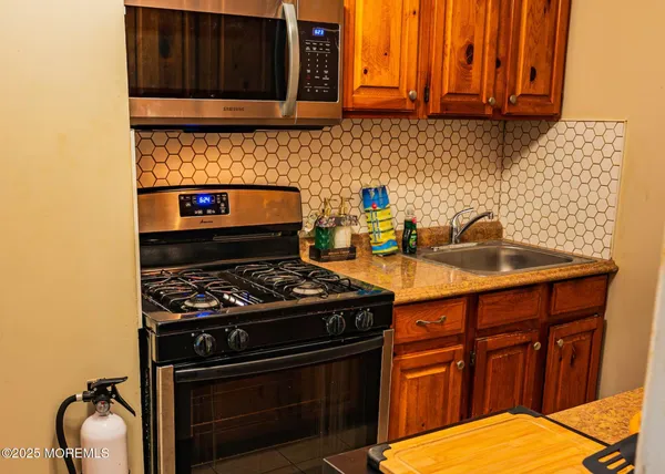 a kitchen with stainless steel appliances granite countertop a stove and a microwave