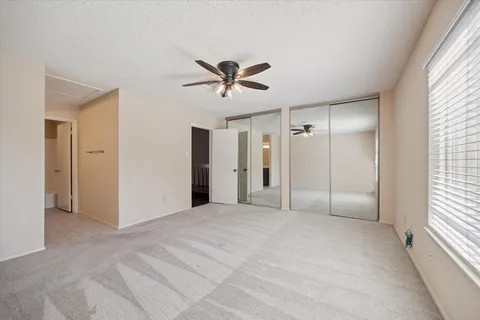 a view of a livingroom with a ceiling fan and window