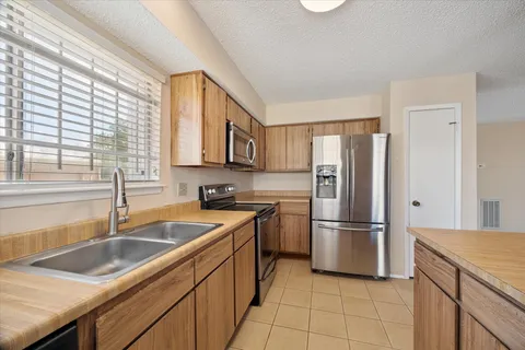 a kitchen that has a sink cabinets counter space and stainless steel appliances