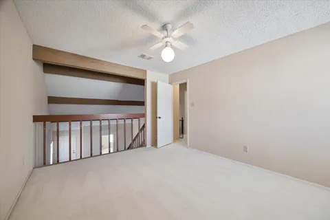 en empty room with windows and ceiling fan