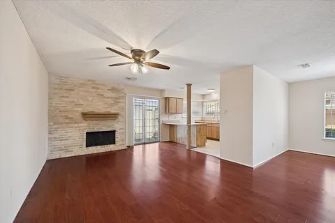 a view of a livingroom with wooden floor and a fireplace