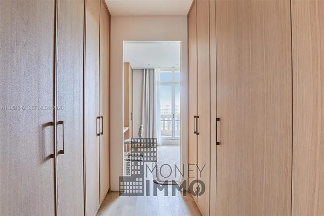 a view of a hallway with wooden floor windows and a bathroom