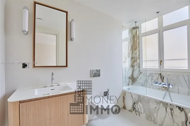 a bathroom with a tub sink and mirror