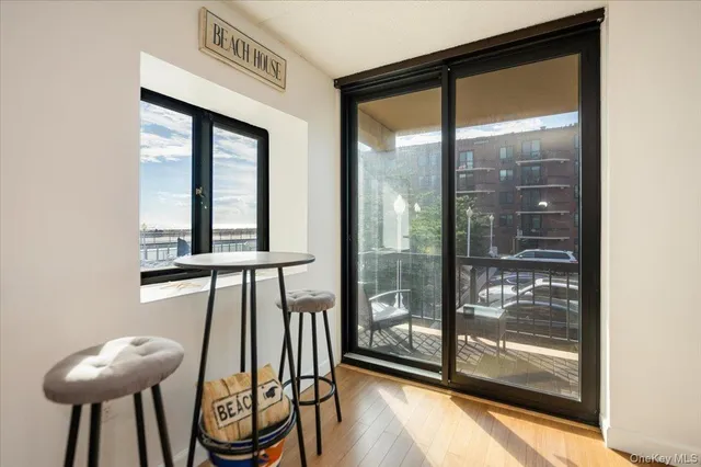 a kitchen with stainless steel appliances kitchen island granite countertop a stove top oven a sink a dining table and chairs with wooden floor