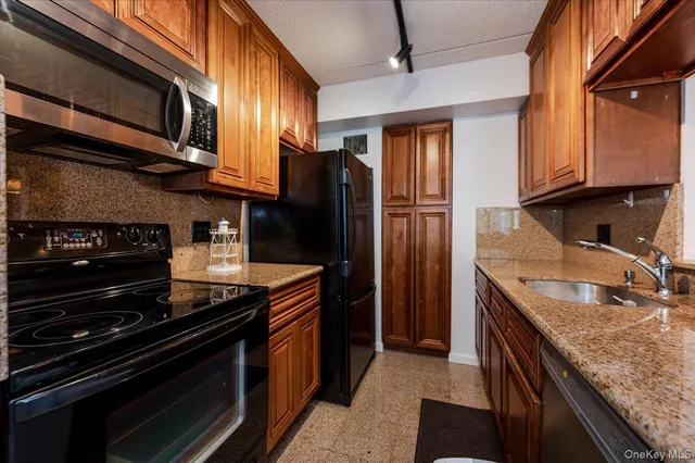 a kitchen with stainless steel appliances granite countertop a sink and stove