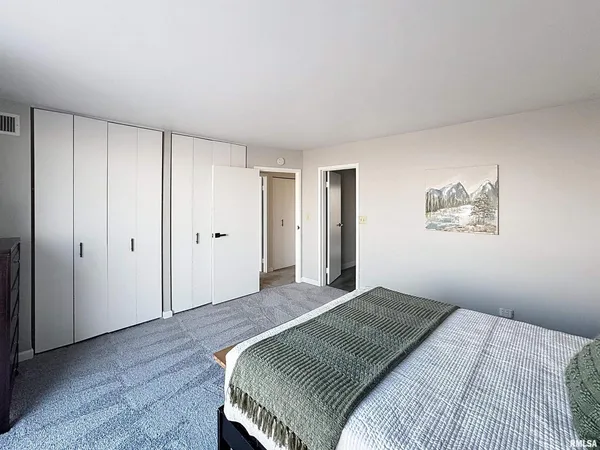 a bedroom with a large bed and a chandelier