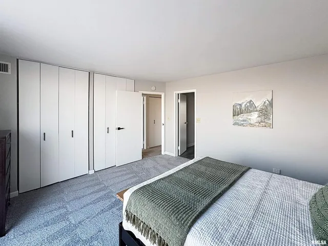 a bedroom with a large bed and a chandelier