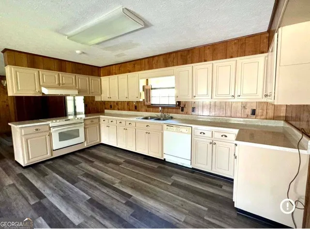 a kitchen with stainless steel appliances a sink window and cabinets