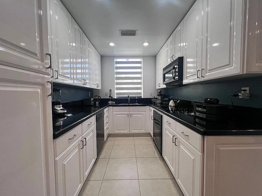 6463 La Costa Drive, Unit 105 Boca Raton, FL 33433 - Photo 4 of 40 a kitchen with granite countertop a sink a stove and cabinets