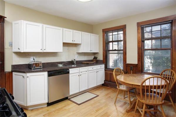 82 Walnut Street, Unit 3 Brookline, MA 02445 - Photo 3 of 4 a kitchen with stainless steel appliances granite countertop a stove top oven a sink a refrigerator and white cabinets
