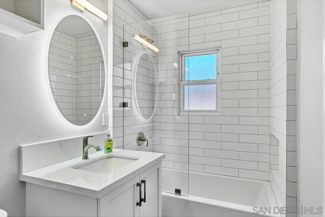 4502 Milton Street San Diego, CA 92110 - Photo 29 of 51 a bathroom with a sink a mirror and a bathtub