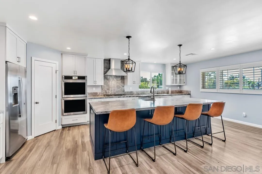 4502 Milton Street San Diego, CA 92110 - Photo 4 of 51 a kitchen with stainless steel appliances a dining table chairs and wooden floor