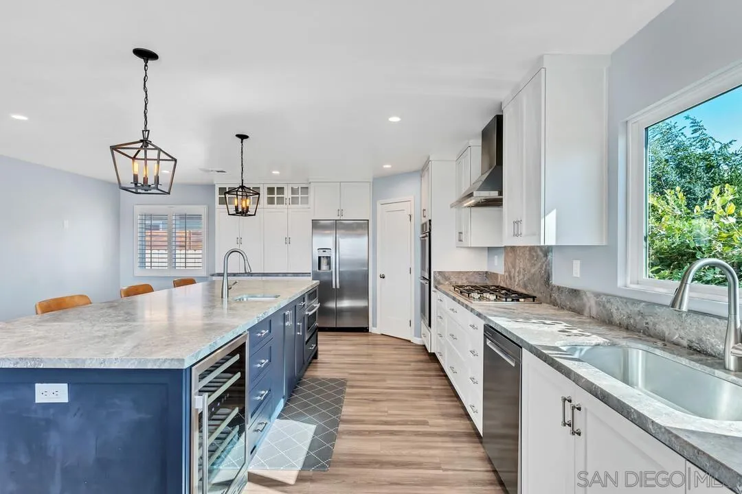 4502 Milton Street San Diego, CA 92110 - Photo 6 of 51 a kitchen with stainless steel appliances granite countertop a sink a stove and a wooden floors