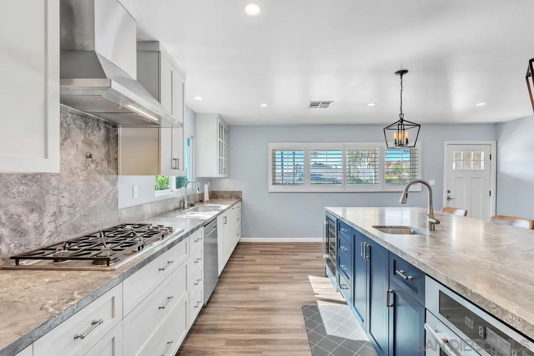 4502 Milton Street San Diego, CA 92110 - Photo 7 of 51 a kitchen with kitchen island granite countertop a sink stove and cabinets