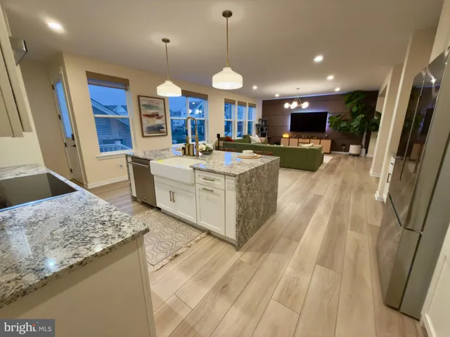 a large kitchen with stainless steel appliances granite countertop a sink a stove and a wooden floors