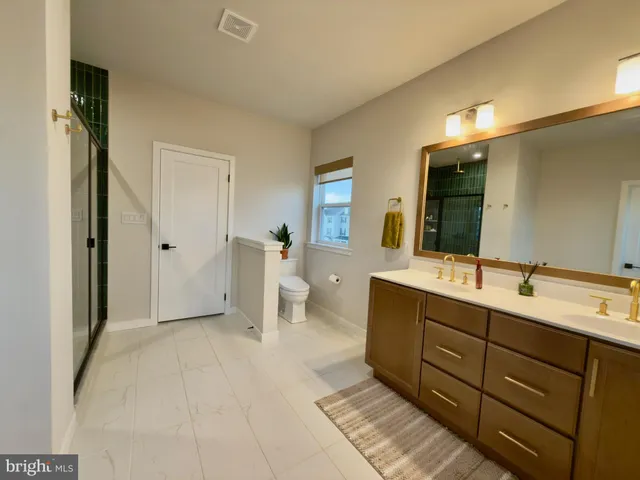 a spacious bathroom with a double vanity sink a mirror and a shower