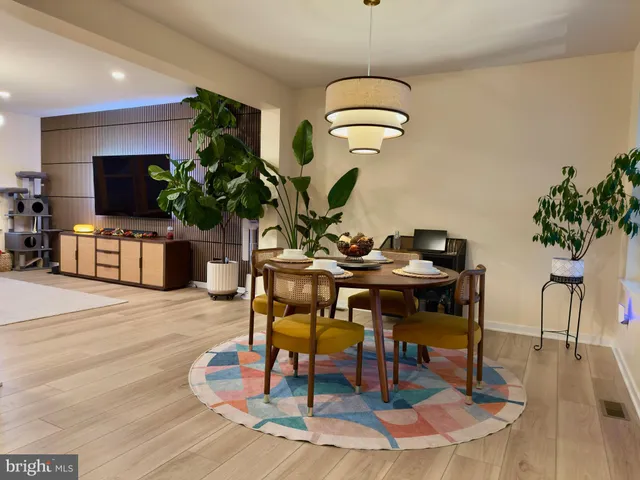 a dining room with furniture a chandelier and wooden floor