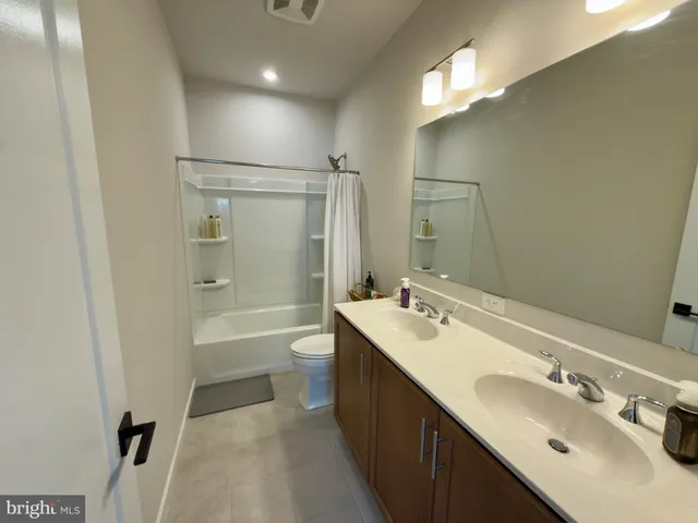 a bathroom with a double vanity sink mirror double and bathtub