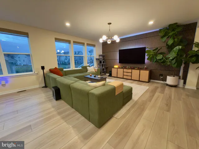 a living room with furniture a flat screen tv and a potted plant