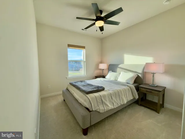 a bedroom with a bed chandelier and a window