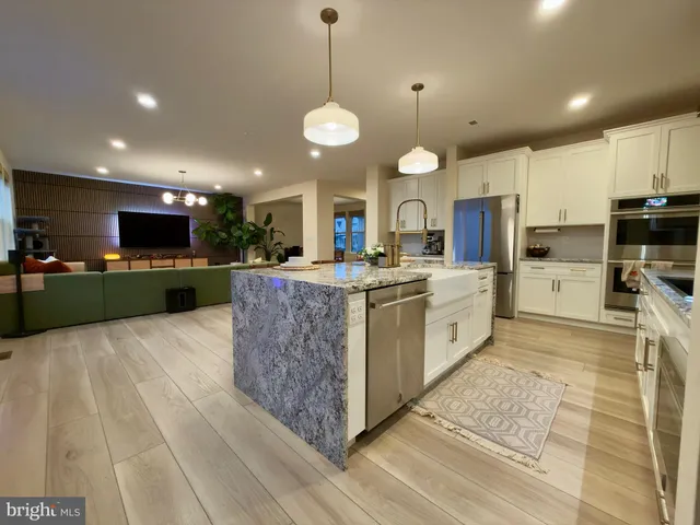 a large kitchen with kitchen island a large island in it