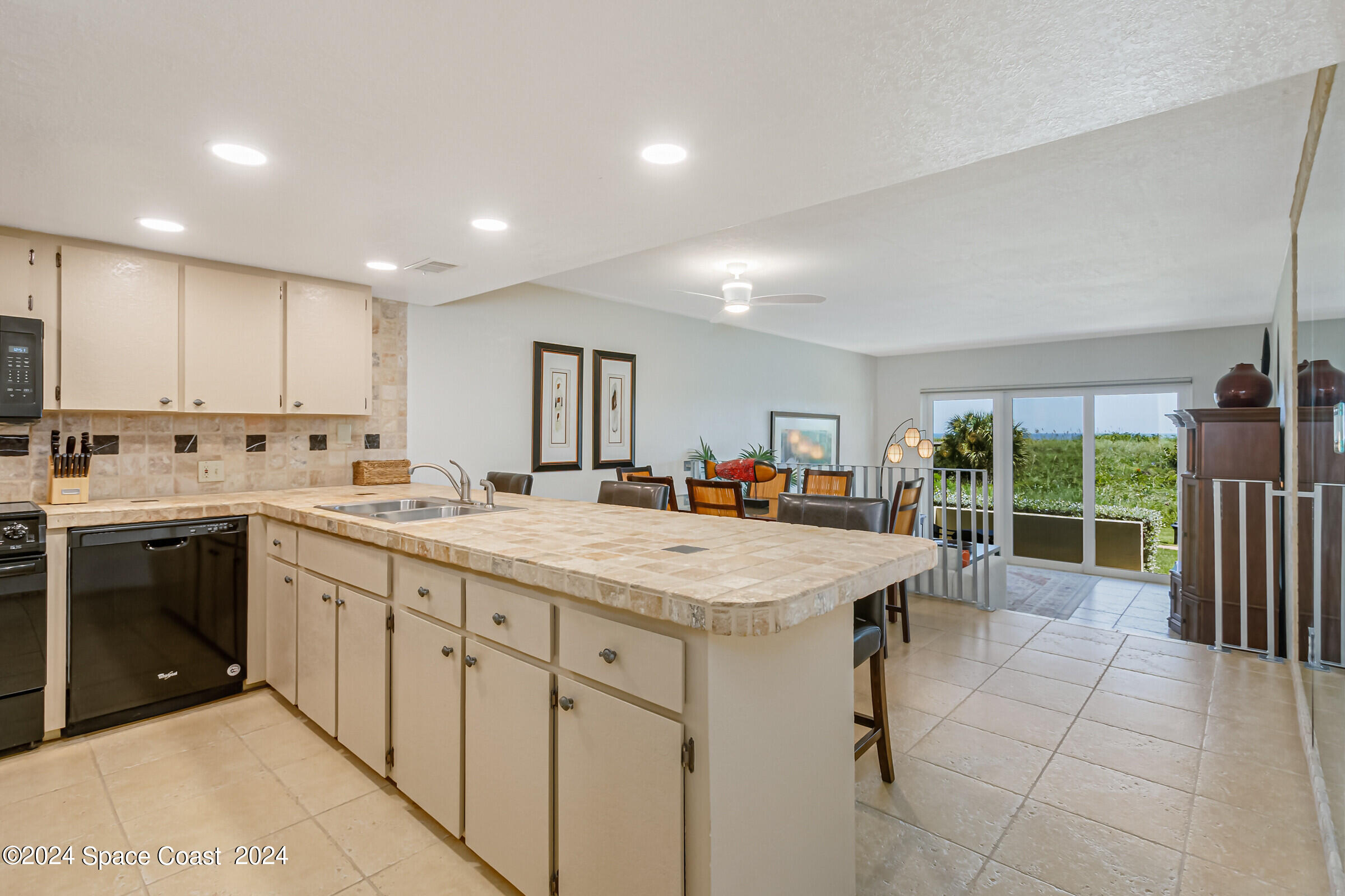 5050 Ocean Beach Boulevard Cocoa Beach, FL 32931 - Photo 12 of 33 a large kitchen with kitchen island a sink stainless steel appliances and cabinets