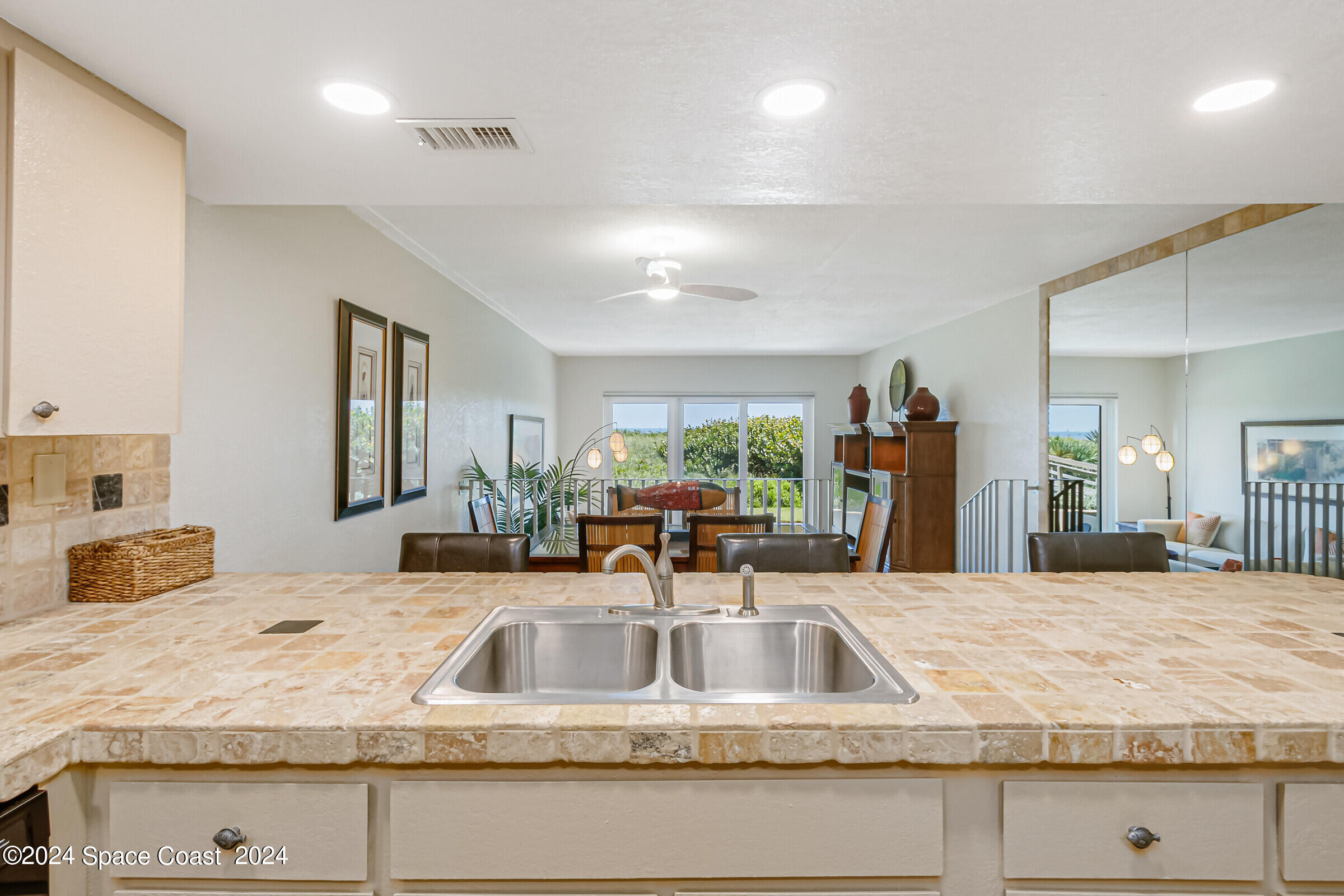 5050 Ocean Beach Boulevard Cocoa Beach, FL 32931 - Photo 14 of 33 a kitchen with granite countertop a sink and a large mirror