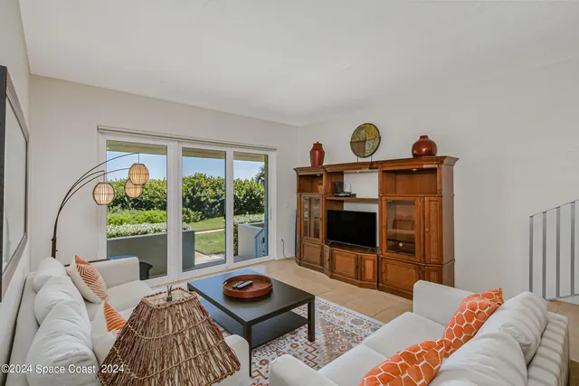 a living room with furniture a window and a flat screen tv