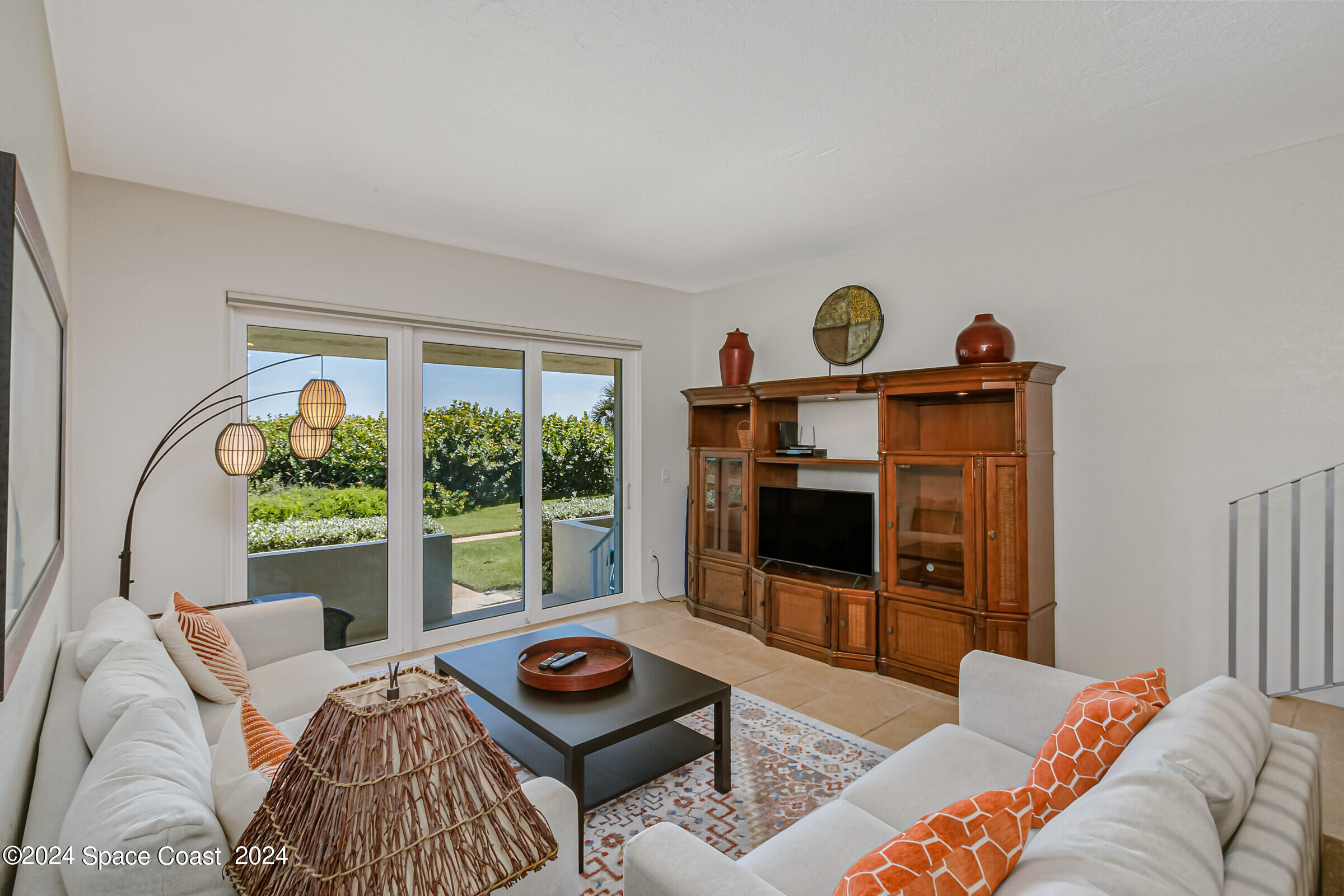 5050 Ocean Beach Boulevard Cocoa Beach, FL 32931 - Photo 18 of 33 a living room with furniture a window and a flat screen tv