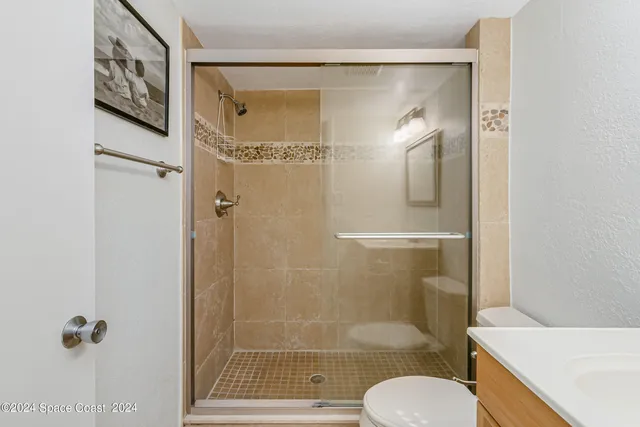 a bathroom with a shower a toilet and a sink