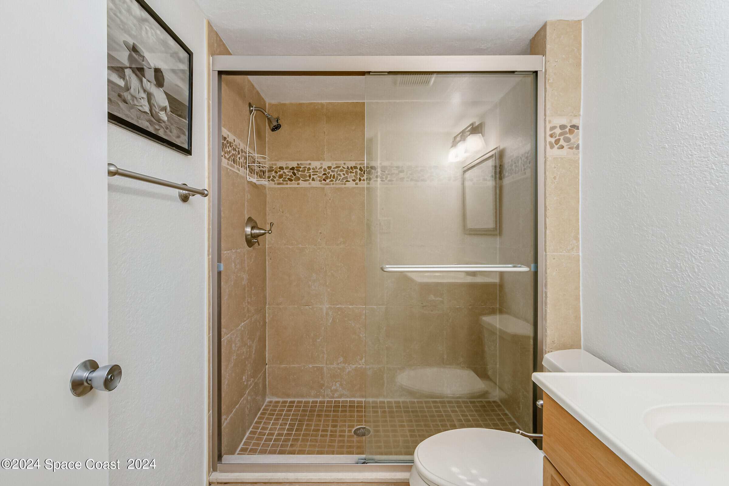5050 Ocean Beach Boulevard Cocoa Beach, FL 32931 - Photo 24 of 33 a bathroom with a shower a toilet and a sink