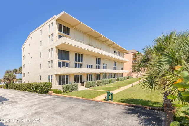 a front view of a building with a garden