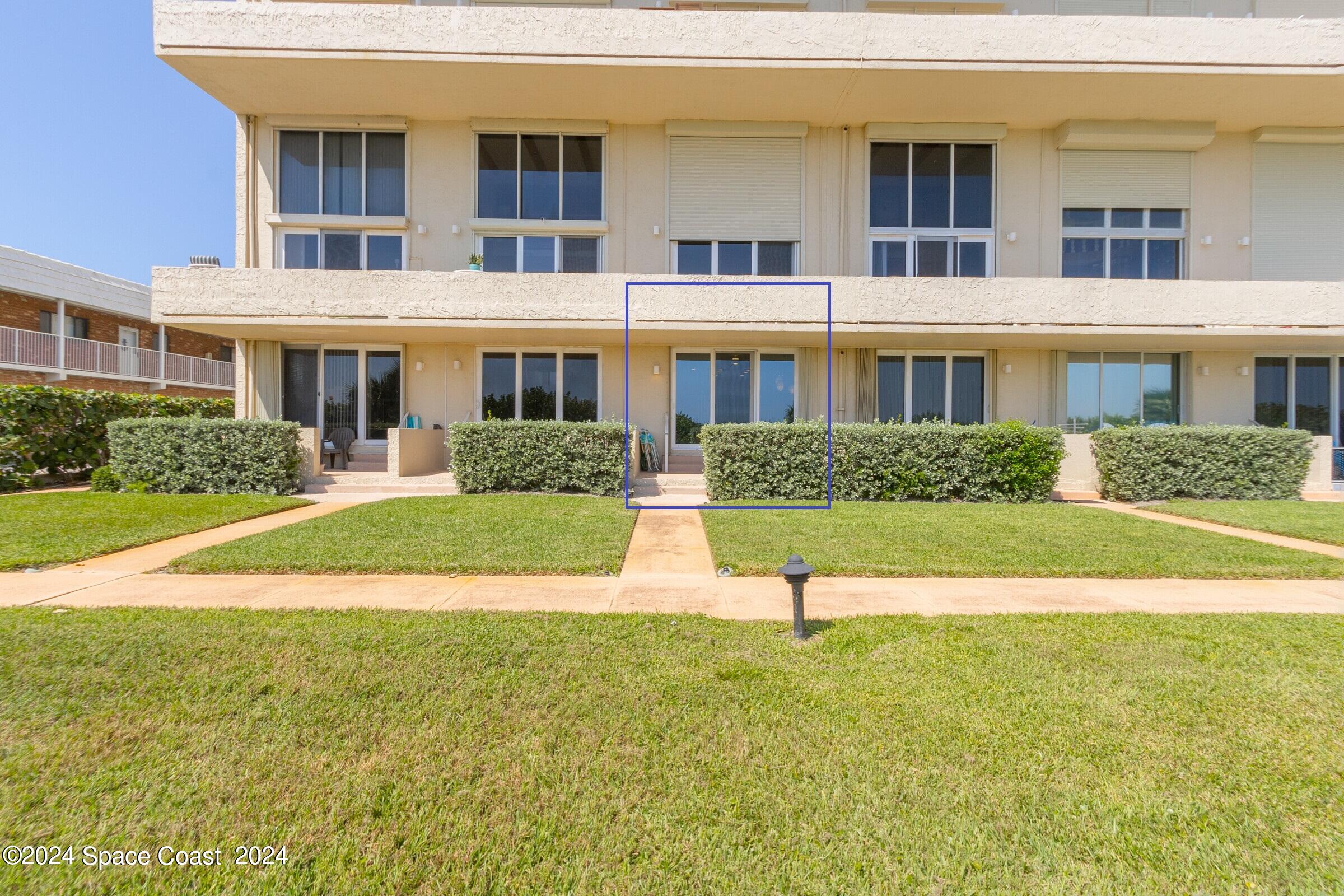 5050 Ocean Beach Boulevard Cocoa Beach, FL 32931 - Photo 28 of 33 a front view of a house with a yard