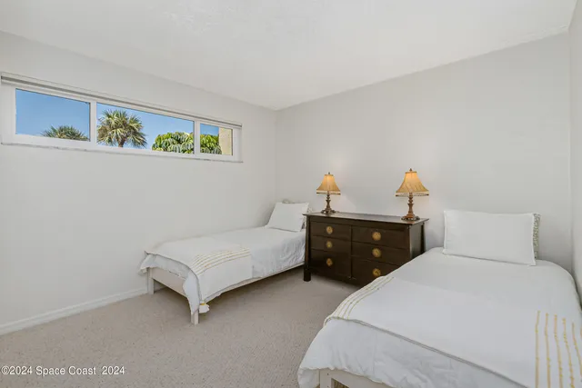 a bedroom with a bed and a lamp on dresser
