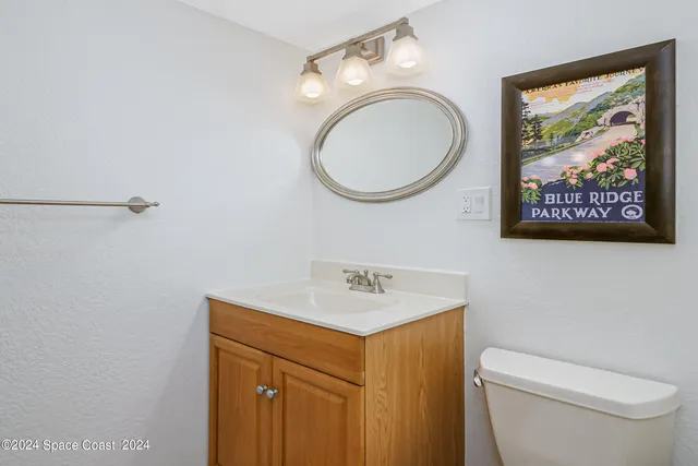 a bathroom with a toilet a sink and a mirror