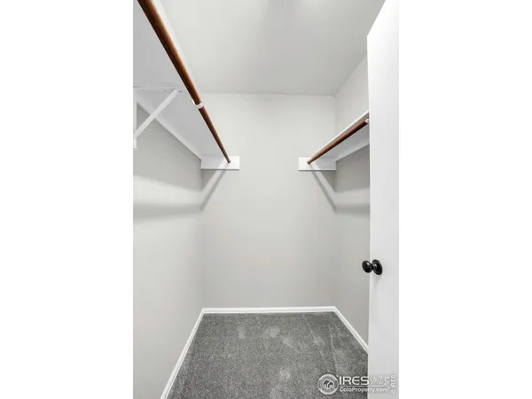 a view of a big room with closet and wooden shelves