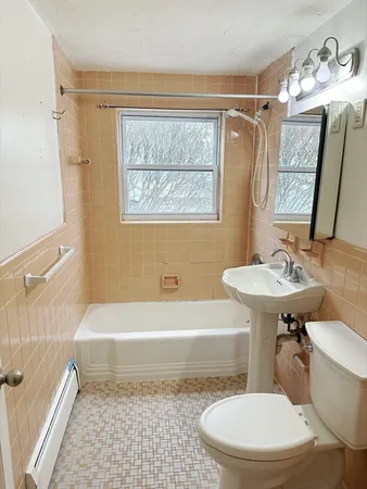 a bathroom with a sink a toilet a mirror and bathtub