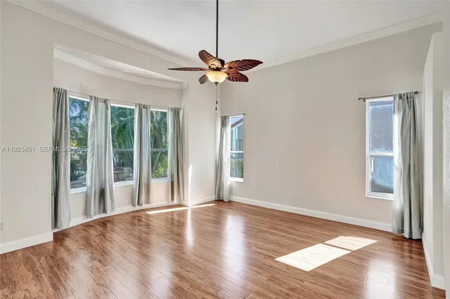 a view of a livingroom with a ceiling fan window and wooden floor