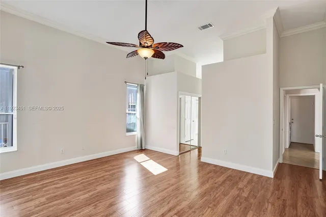 a view of a room with wooden floor and ceiling fan