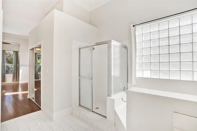 a bathroom with a granite countertop sink a mirror a bathtub and shower