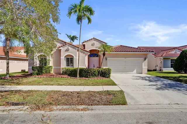 a front view of a house with a garden and yard